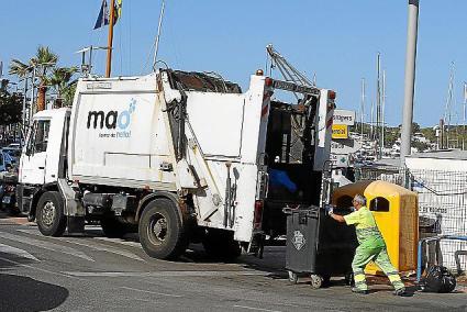 MAHON. RECOGIDA BASURA . Un operario vaca un contenedor en el puerto de Ma .