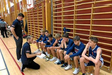 Joan Nuevo, en cuclillas, dando instrucciones a los jugadores sub-16 del Kungsbacka Basketklubb.