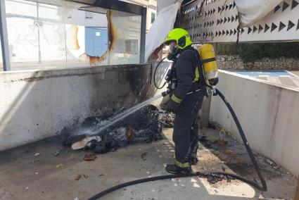 Un bombero sofoca el contenedor incendiado