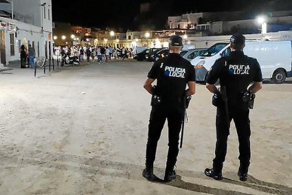 En Es Pla. Una pareja de policías locales observa la retirada de otro grupo de jóvenes en la zona de ocio del puerto de Ciutadella, durante la madrugada del pasado viernes