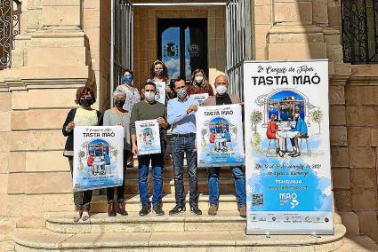 Los organizadores del concurso posando con el cartel frente al Ayuntamiento