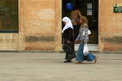 Dos mujeres de origen magrebí pasean por la plaza de la catedral de Ciutadella.