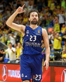 Sergio Llull alza la mano derecha mientras orienta su mirada al electrónico del mítico pabellón La Mano de Elías de Tel Aviv después de convertir un tripl