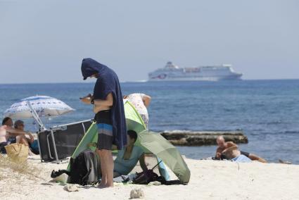 En la playa de Punta Prima, los bañistas buscaban ayer el refugio del sol debajo de las sombrillas o cubiertos por toallas.