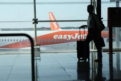 Un pasajero pasa frente a un avión de la compañía Easyjet en Barcelona.