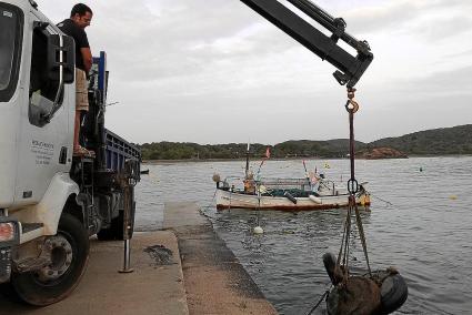 Una grúa saca del agua los muertos que previamente los buzos han acercado a los muelles