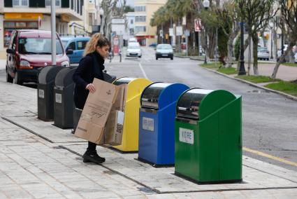 Una mujer deposita un cartón en los contenedores situados en la plaza de Es Pins de Ciutadella.