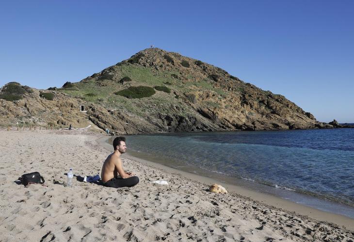 Un hombre tomando el sol en la playa de Sa Mesquida.