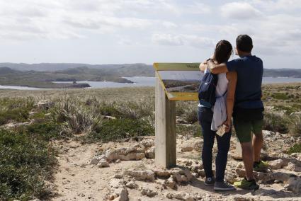 Una pareja en el mirador de Cavalleria, al fondo, la torre de Sanitja y la playa de Cavalleria.