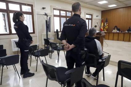 Dos policías custodian  al acusado durante el juicio de este miércoles.