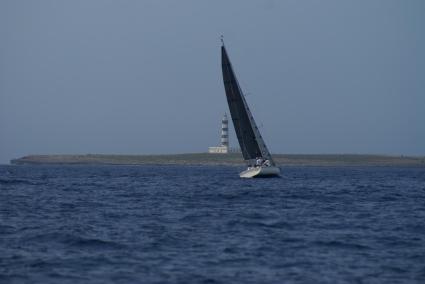 Un velero navega frente a la Illa de l'Aire.