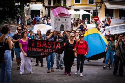 Manifestantes portan una pancarta contra el negocio que se realiza con la vivienda.