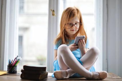 Una niña utilizando un teléfono móvil