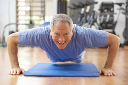 Senior Man Doing Press Ups In Gym