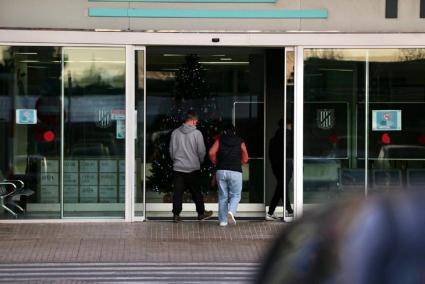 Dos pacientes acceden al interior del Hospital Mateu Orfila. Los casos de gripe y covid-19 aún no tensionan la sanidad en la Isla