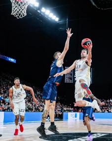 Sergio Llull elude por elevación la marca de un defensor, con Eddy Tavares atento a la acción.   