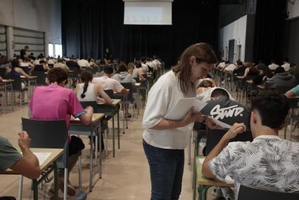 Una profesora reparte los exámenes en la sala multifuncional del Canal Salat de Ciutadella.