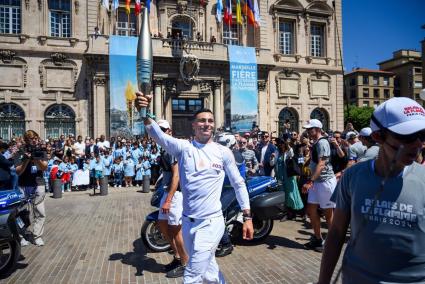 Archivo - Un relevista portando la antorcha olímpica.