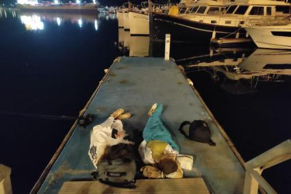 Dos jóvenes pasan la noche al raso en un muelle del puerto de Maó esta semana.