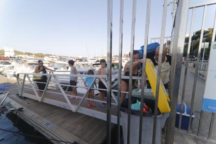 Amarristas depositan las bolsas de basura después de un día de navegación ayer por la tarde en un pantalán del puerto.