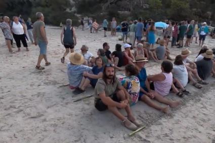 Manifestantes contra la masificación sentados en la arena de Cala en Turqueta el pasado julio.