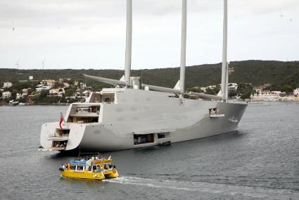 Un megayate y un barco de paseos turísticos en el puerto de Maó.