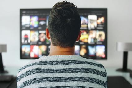 Un hombre joven ve la televisión.