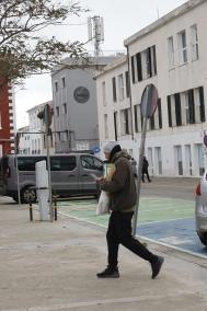 Un residente en Es Castell camina con su teléfono móvil en la mano por la plaza Explanada. Al fondo, el hotel Pardela Menorca y la antena sobre su azotea, que la compañía ahora tendrá que reubicar en otro edificio.   