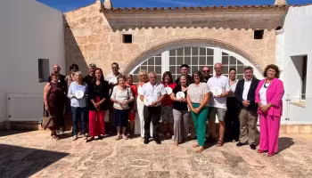 Representantes de los siete comercios posan con las autoridades, ayer en Can Saura.