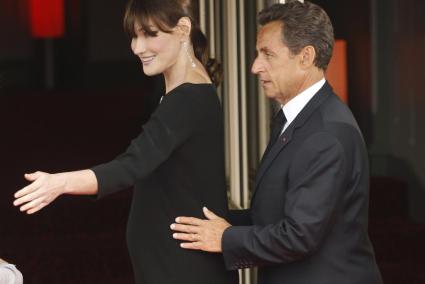 File photo of French President Nicolas Sarkozy putting his hands on his pregnant wife Carla Bruni-Sarkozy at the G8 Summit in De