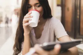 Una mujer tomando un café en una terraza