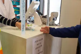 Una mujer compra mascarillas en una farmacia.